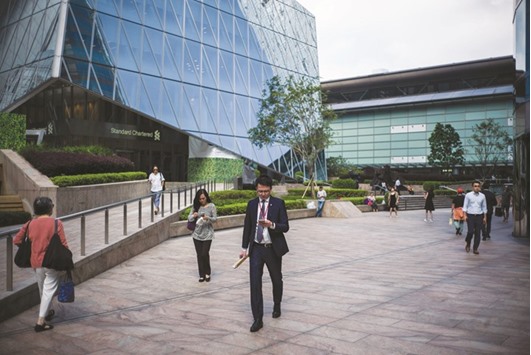People walk outside the Hong Kong Stock Exchange building. The Hang Seng Index eked out a slight gain yesterday, after closing at a three-week low on Monday.