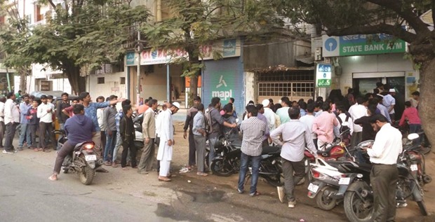 People queue up outside an ATM in Hyderabad yesterday. Long queues were seen outside banks and ATMs all across the country.