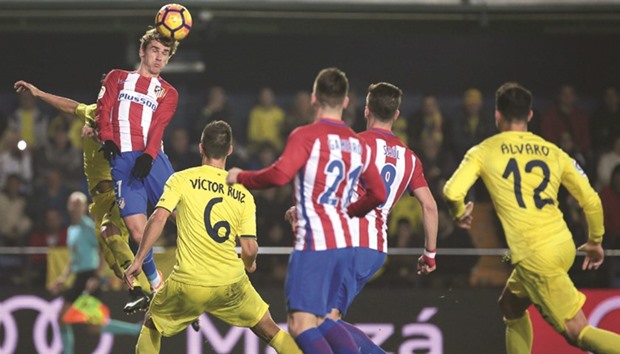 Atletico Madridu2019s French forward Antoine Griezmann (L) heads the ball during the Spanish La Liga match at El Madrigal stadium in Villarreal on Monday.
