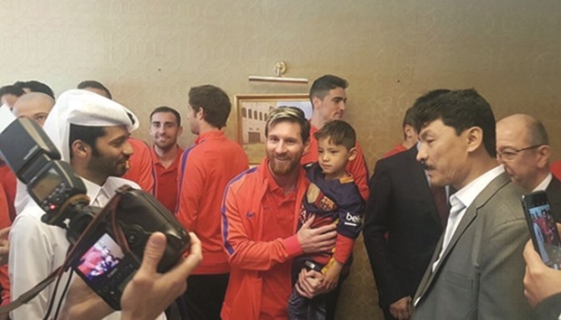 A handout picture released by Qataru2019s Supreme Committee for Delivery and Legacy shows Barcelonau2019s Argentinian forward Lionel Messi (C-L) holding six-year-old Afghan boy Murtaza Ahmadi (C-R) in Doha yesterday.