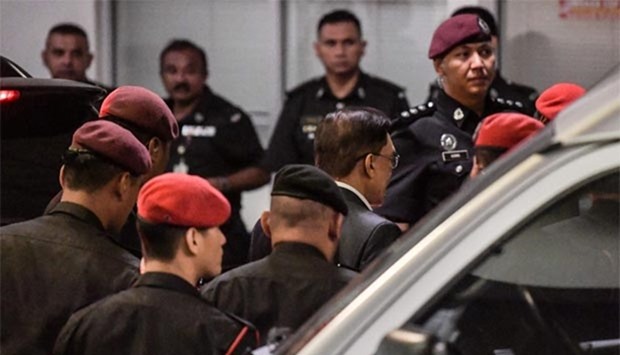 Jailed Malaysian politician Anwar Ibrahim (second right) is escorted by prison security during his arrival at the federal court in Putrajaya on Wednesday.