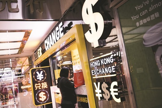 A customer stands at a currency exchange store in Hong Kong. Asiau2019s dollar bond market could be one of the biggest casualties of Chinau2019s crackdown on cash leaving the country.