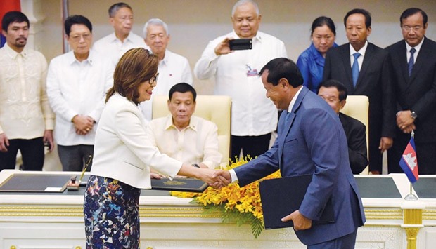 Secretary of the Philippines Department of Tourism Wanda Corazon Tulfo-Teo (front left) shakes hands with Cambodian Minister of Tourism Thong Khon as Philippines President Rodrigo Duterte and Cambodian Prime Minister Hun Sen look on during a signing ceremony at the Peace Palace in Phnom Penh yesterday.