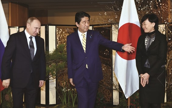 Japanese Prime Minister Shinzo Abe leads Russian President Vladimir Putin upon his arrival at a hotel prior to their talks in Nagato, Yamaguchi prefecture yesterday while Akie Abe, wife of the prime minister looks on.