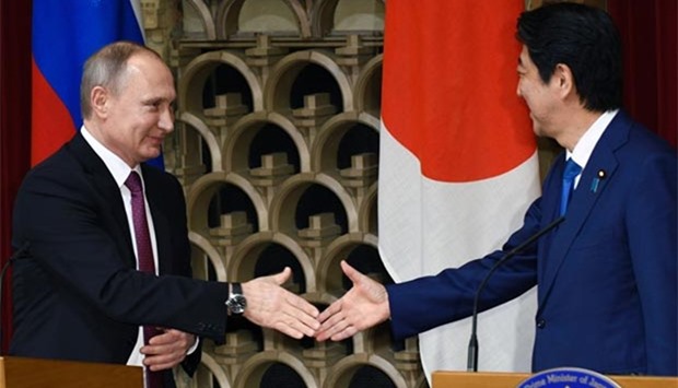 Russian President Vladimir Putin and Japanese Prime Minister Shinzo Abe shake hands at the end of their joint press conference at Abe's official residence in Tokyo on Friday.