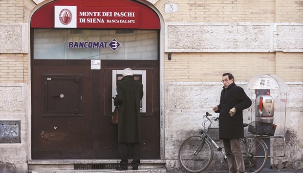 Customers wait to use an ATM outside a branch of Monte dei Paschi di Siena in Rome. Monte dei Paschi, advised by investment banks JPMorgan and Mediobanca, plans to raise equity to remove u20ac28bn in bad loans from its books.