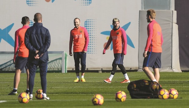 Barcelonau2019s midfielder Andres Iniesta (L) and Barcelonau2019s Argentinian forward Lionel Messi take part in a training session.