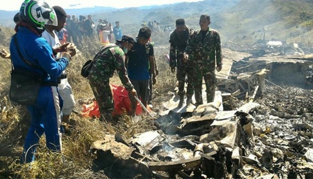 Indonesian soldiers examining the Hercules military plane A-1334 that crashed in Wamena on Sunday.