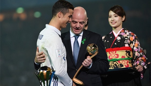 FIFA president Gianni Infantino (C) gives the Golden Ball trophy to Real Madrid's forward Cristiano Ronaldo (L)