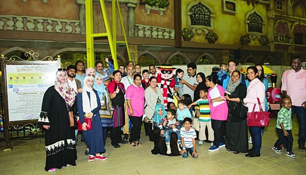 Participating children and their families pose for a group photo during an event marking International Day of Persons with Disabilities at HMC