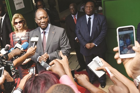 President Ouattara answers journalists after voting at a polling station in Cocody, a commune of Abidjan.