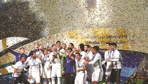 Real Madrid players celebrate with their trophy after winning the Club World Cup football final match against Kashima Antlers of Japan in Yokohama yesterday.