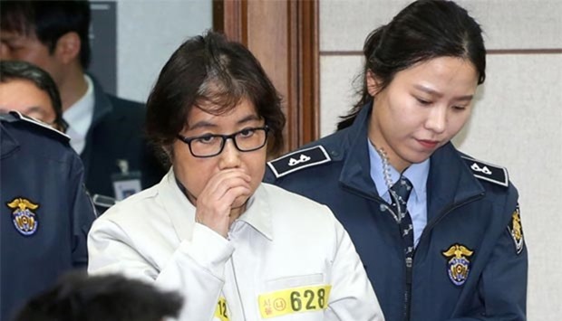 Choi Soon-Sil (C), who has been dubbed Korea's ,female Rasputin, for the influence she wielded over the now-impeached president Park Geun-Hye, arrives at a courtroom for her trial at the Seoul Central District Court in Seoul on December 19, 2016.