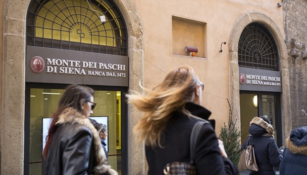 Pedestrians pass by a Monte dei Paschi branch in Siena. Italyu2019s third-largest bank has until the end of December to raise capital and offload u20ac28bn in gross bad loans as requested by European Central Bank supervisors.