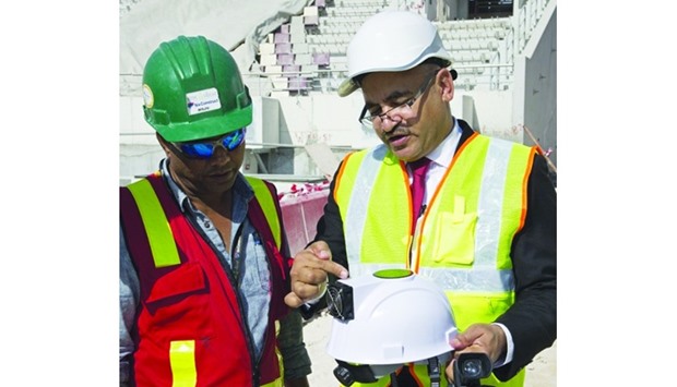 Dr Abdul-Ghani (right) explains about the innovative cooled helmet during a site visit to Khalifa International Stadium in Doha