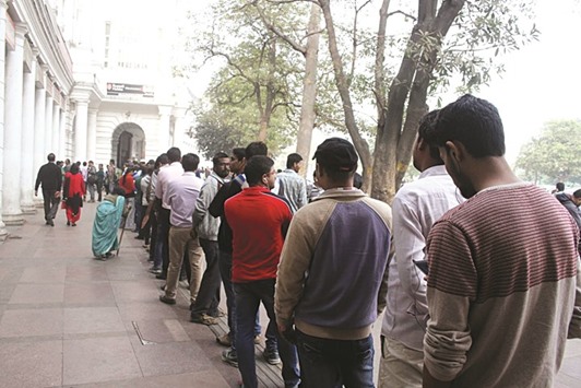 People queue up outside an ATM in New Delhi yesterday. There was no respite in sight for the cash-strapped people.