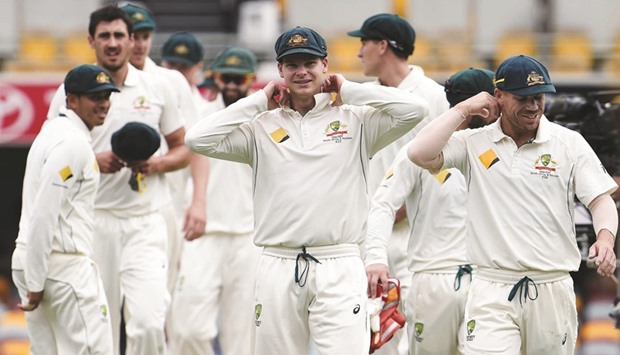 Australiau2019s captain Steve Smith (centre) adjusts his collar as he walks off the field with teammates after beating Pakistan in the first Test in Brisbane yesterday. (AFP)