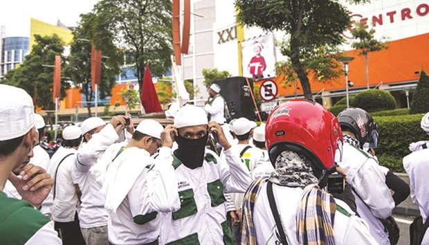 Protesters from the Islamic Defenders Front (FPI) demonstrate outside a shopping mall in Surabaya, in a rally to stop retail workers from wearing Santa hats inside malls.