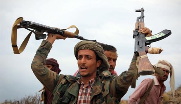 A Yemeni tribesman from the Popular Resistance Committee, supporting forces loyal to Yemen's Saudi-backed President Abedrabbo Mansour Hadi, raises weapons during clashes with Houthi rebels in Taez on Monday.
