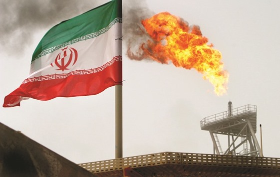A gas flare on an oil production platform in the Soroush oil fields is seen alongside an Iranian flag in the Gulf (file). Since sanctions on its economy were eased in January, the Gulf producer has doubled exports as prices rallied and won approval from Opec last month to pump even more while other members cut. The key to continued growth will be attracting foreign investment to the energy industry.