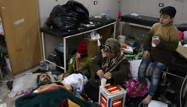 A Syrian woman takes care of her husband at the only functioning hospital in the last rebel-held pocket of Syria's northern city of Aleppo as people wait to be evacuated on December 18, 2016