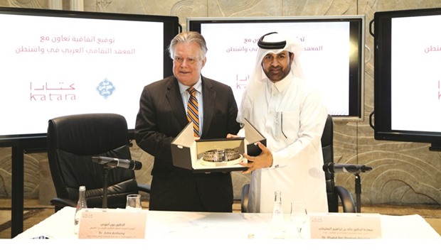 Dr Khalid bin Ibrahim al-Sulaiti (right) presenting a memento to Dr John Duke Anthony at the signing of a co-operation agreement at Katara yesterday.
