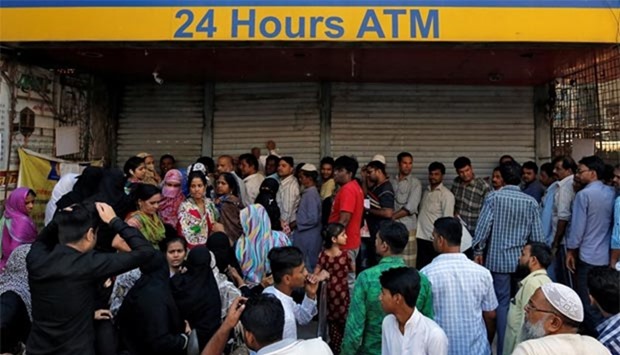People queue outside a bank to withdraw cash and deposit their old high denomination banknotes in Mumbai on Friday.
