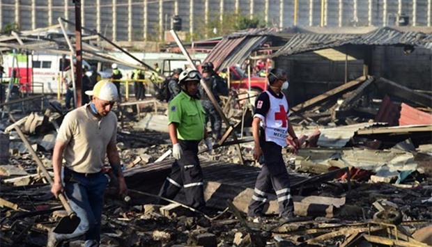 Rescue workers search the debris left by a huge blast in a fireworks market in Mexico City.