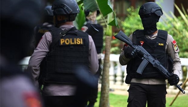 Indonesian police officers stand outside a home following a gunfight in which three suspected militants were killed in South Tangerang, Banten province near Jakarta.
