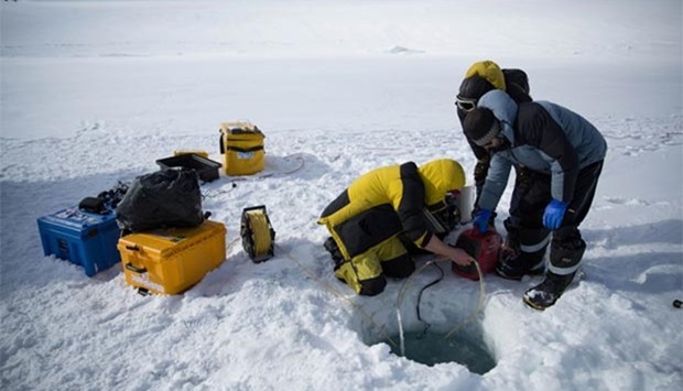 Scientists operating a remote underwater camera through a hole in the ice at O'Brien Bay near Australia's Antarctic Casey research station.