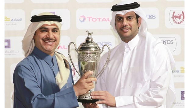 Qatar Equestrian Federation president Hamad Abdulrahman al-Attiyah (right) presents the trophy to trainer Jassim Ghazali after The Blue Eye won the HH Sheikh Mohammed Bin Khalifa Al Thani Trophy (Gr2) at the Qatar Racing and Equestrian Club (QREC) yesterday. PICTURES: Juhaim