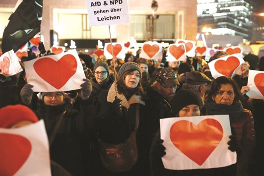 People hold up signs with hearts while participating in a rally for the victims of an attack at the Christmas market at the Kaiser-Wilhelm-Gedaechtniskirche (Kaiser Wilhelm Memorial Church), in Berlin, yesterday.