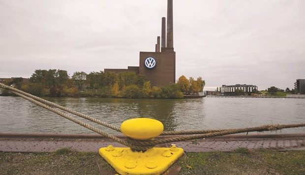 Mooring ropes are seen tied to a cleat as the Volkswagen headquarters stand beyond on the bank of the Aller river in Wolfsburg, Germany. Yesterdayu2019s deal includes pledges by Volkswagen to spend $225mn to mitigate environmental damage its vehicles caused and $25mn to support the use of zero-emission models, the California Air Resources Board and the US Department of Justice said in statements.