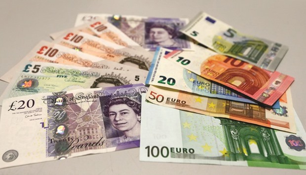 British pound and euro banknotes are pictured in a bank in Munich. Sterling is on track for its biggest annual decline against the euro since 2008, and the median forecast in a Bloomberg survey of economists sees the pair reaching 86 pence by the end of next year, with a range of 73 pence to one pound per euro.