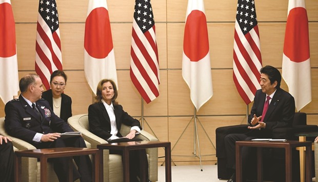Japanese Prime Minister Shinzo Abe speaks to US Ambassador to Japan Caroline Kennedy (centre) and Lieutenant General Jerry P Martinez, commander of US Forces Japan (left) during a joint announcement on the return of American military to the island of Okinawa at the Abeu2019s official resident in Tokyo yesterday.