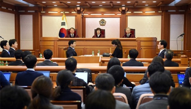 (Top L-R) South Korea's Constitutional Court judges Lee Jin-Sung, Lee Jung-Mi and Kang Il-Won attend the hearing