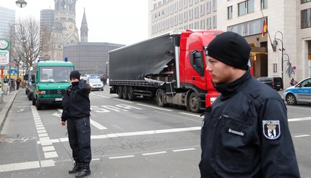 Policemen are seen in front of the truck which ploughed into a crowded Christmas market 