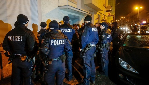 Policemen stand in front of a house in Dortmund, western Germany