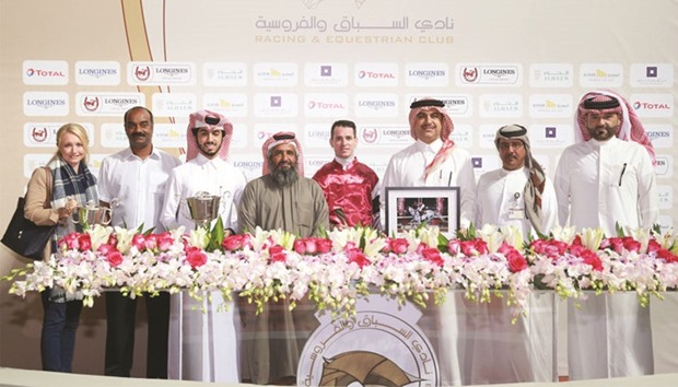 Muraikh District Municipal Council member Mohamed Salem al-Qamara al-Marri (fourth from left) and Qatar Racing and Equestrian Club (QREC) vice-chief steward Abdulla Rashid al-Kubaisi (second from right) with the winners of the Muraikh Cup after My Sharona won the 1100m race for Thoroughbreds at the QREC yesterday. PICTURES: Juhaim