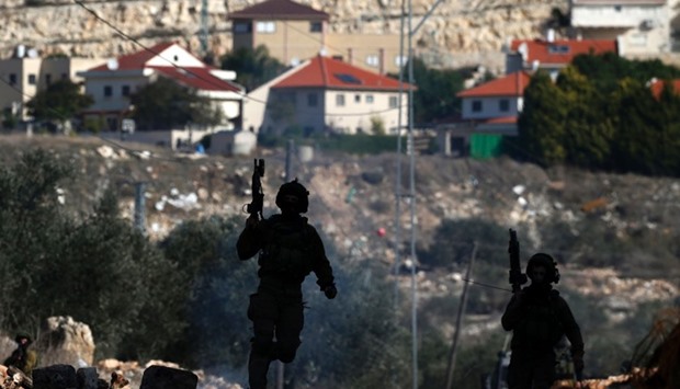 Israeli security forces take position near the settlement of Kadumim (background) during clashes following a demonstration against the expropriation of Palestinian land by Israel in the village of Kfar Qaddum, in the occupied West Bank