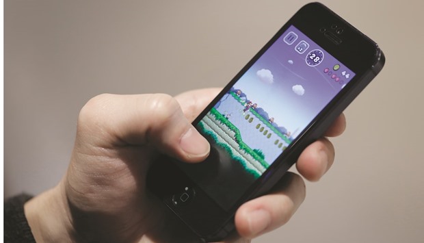 A man plays Nintendou2019s Super Mario Run mobile game on an Apple iPhone in Tokyo. The game is free to download on the App Store where, in Japan, it is rated 2.5 stars out of 5 based on 1,095 reviews.