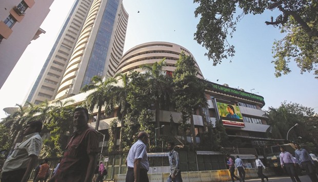 People walk by the Bombay Stock Exchange building in Mumbai. The BSE Sensex closed up 0.24% to 26,040.70 points yesterday.