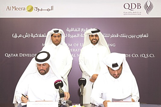 Al-Kubaisi and Dr al-Sowaidi signing the MoU between QDB and Al Meera in the presence of Sheikh Thani and al-Khalifa.