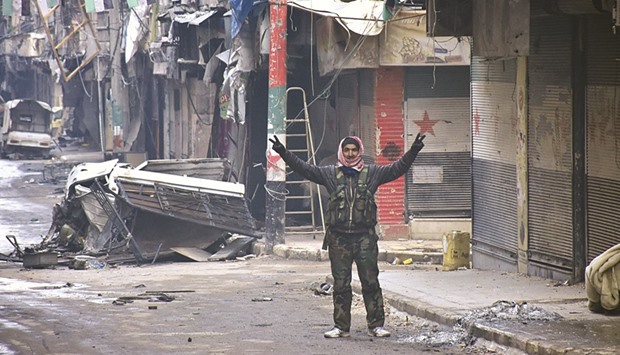 A Syrian man gestures in the former rebel-held Salaheddin district in the northern Syrian city of Aleppo after Syrian government forces retook control of the whole embattled city.