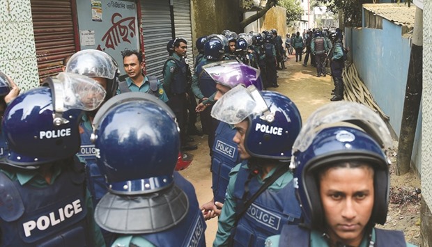 Police officials stand alert at the scene of an operation to storm an alleged militant hideout in Dhaka yesterday, as a team from the counter-terrorism unit of Dhaka Metropolitan Police cordoned off a three-storey building in the capital.