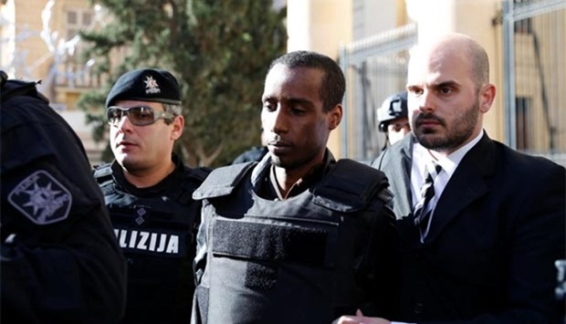 One of two men who hijacked a Libyan Afriqiyah Airways plane to Malta is escorted by heavily-armed police officers out of the law court in Valletta on Sunday.