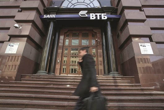A pedestrian walks past a branch of VTB bank in Moscow. International banksu2019 apprehension about dealing with Russia has helped VTBu2019s investment banking arm VTB Capital increase its Russian fee income this year to over $90mn from $56mn in 2015, making it the only major industry player to exceed what it made in Russia in 2013.