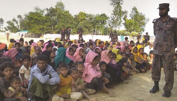 Rohingyas from Myanmar, who tried to cross the Naf river into Bangladesh to escape sectarian violence, are kept under watch by Bangladeshi security officials in Teknaf yesterday.