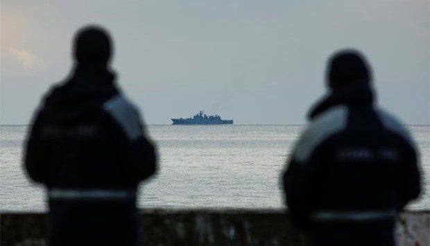 Rescue personnel watch on a pier as a navy ship sails near the crash site of a Russian military Tu-154 plane, in the Black Sea resort city of Sochi on Monday.