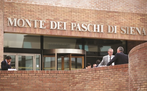 Pedestrians stand outside the administrative offices of Banca Monte dei Paschi in Siena. The outlines of a rescue for Monte Paschi were announced on December 22, and while some aspects of the plan remain hazy, the challenge to the EUu2019s efforts to sever the link between banks and states is clear.